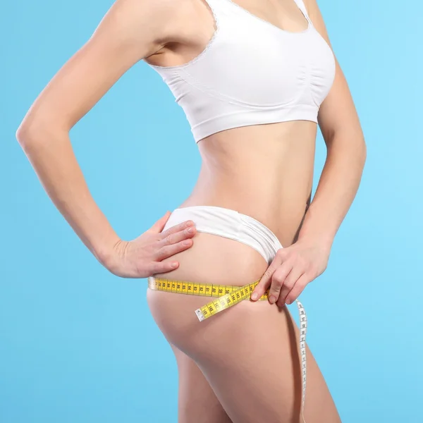 Woman with measure tape over white — Stock Photo, Image