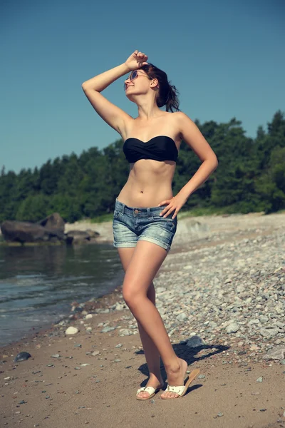 Mulher em shorts sexy posando na praia — Fotografia de Stock