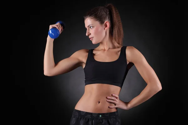 Beautiful sporty muscular woman working out with dumbbells — Stock Photo, Image