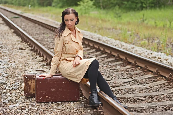 Mujer con una maleta en los rieles — Foto de Stock