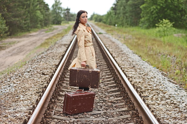woman with a suitcase on the rails