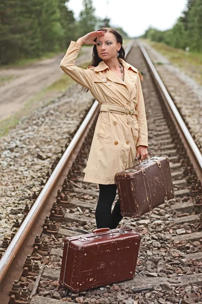 Vrouw met een koffer op de rails — Stockfoto