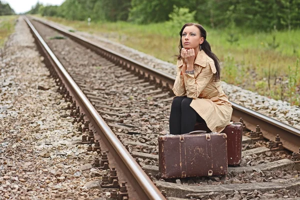 Vrouw met een koffer op de rails — Stockfoto