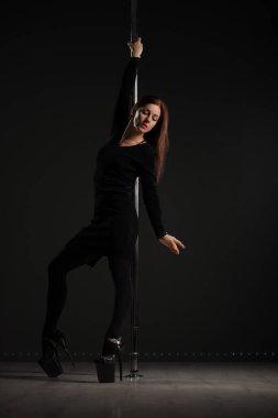 Atletik kadın zarif bir direk dansı yapıyor.