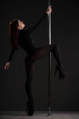 Atletik kadın zarif bir direk dansı yapıyor.