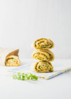 Ev yapımı sarımsaklı çörekler, yeşil maydanozlu ve peçeteli tatlı biberli beyaz arka plan.
