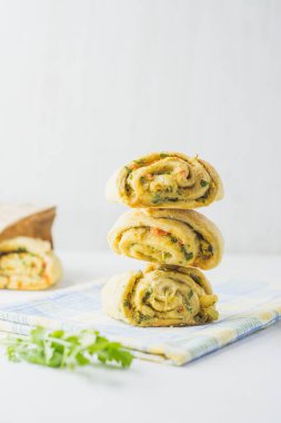 Ev yapımı sarımsaklı çörekler, yeşil maydanozlu ve peçeteli tatlı biberli beyaz arka plan.