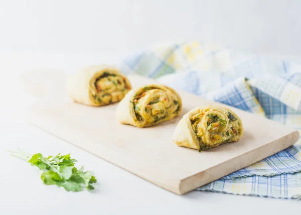 Home made buns with garlic, green parsley and sweet pepper in a napkin and wooden cutting board white background. — Stock Image Home Made Buns Garlic Green Parsley Sweet Pepper Napkin Wooden Stock Photo