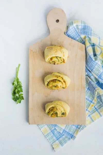 Home made buns with garlic, green parsley and sweet pepper in a napkin and wooden cutting board white background. — Stock Image Home Made Buns Garlic Green Parsley Sweet Pepper Napkin Wooden Stock Picture
