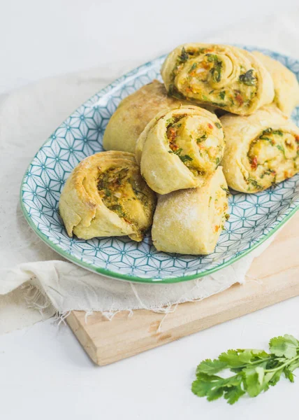 Home made buns with garlic, green parsley and sweet pepper in a plate with napkin and wooden cutting board white background. — Stock Image Home Made Buns Garlic Green Parsley Sweet Pepper Plate Napkin Stock Image