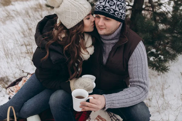 Una giovane donna bruna bacia un uomo sulla guancia. — Foto Stock