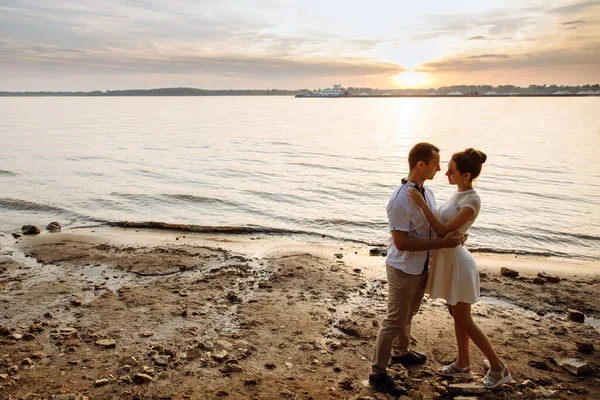 Aşk dolu erkek ve kadın nehir kıyısında dururken sarılıyorlar.