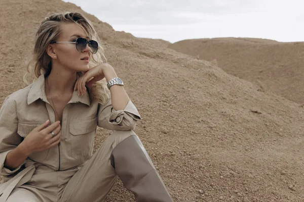 Çekici bir kadın kum tepelerinin arasında oturuyor.. 