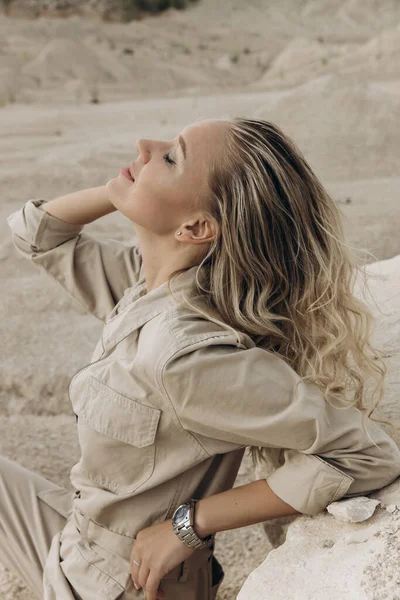 Safari kıyafeti giymiş genç bir kadın. Sarışın dinleniyor..