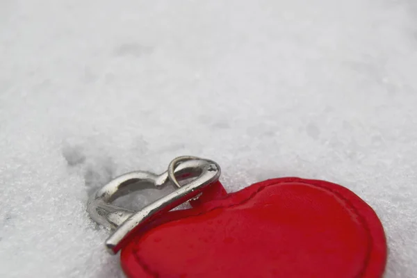 Two hearts, one big red, the other small silver on white sparkling snow. Romantic concept. Love and Saint Valentine — Stock Photo, Image