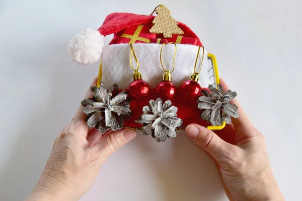 Womans hand arranging Christmas items in a basket. Christmas and New Year decoration concept.