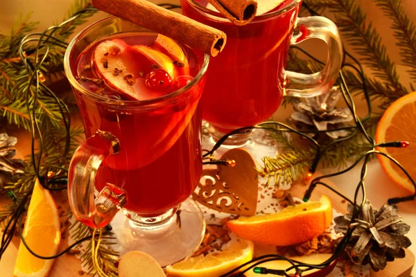 Glühwein mit Gewürzen und Weihnachtsbaum auf einem hölzernen Hintergrund am Fenster — Stockfoto