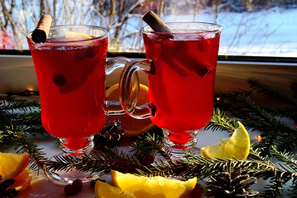 Glödvin med kryddor och julgransgrenar på ett ljust fönsterbräde, utomhus är det vinter. Julsemester och hem värme koncept. — Stockfoto