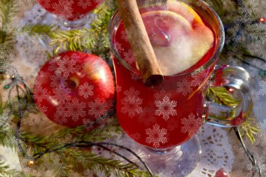 Baharatlı şarap ve yılbaşı ağacının dalları açık pencere pervazında, kar tanelerinin bokeh etkisi ile üst manzara. Noel tatili ve ev sıcaklığı kavramı