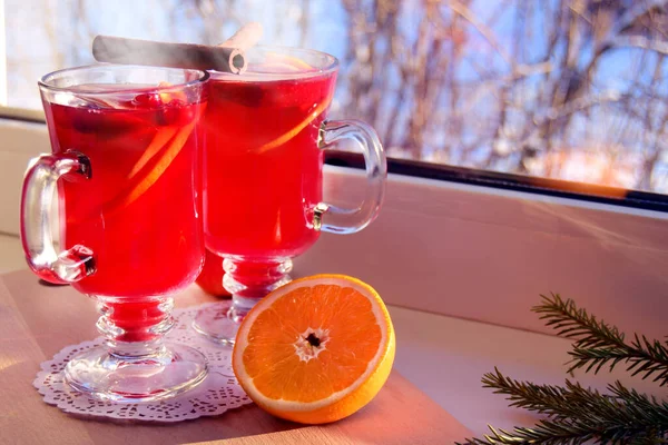Glühwein mit Gewürzen und Orange auf einem Holzbrett, das auf einem hellen Fensterbrett steht. Weihnachtsurlaub und Wärmekonzept zu Hause. — Stockfoto
