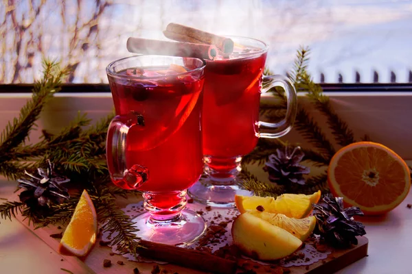 Glödvin med kryddor och julgransgrenar på ett ljust fönsterbräde, utomhus är det vinter. Julsemester och hem värme koncept. — Stockfoto