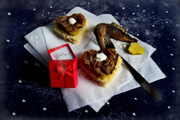 Kırmızı kurdeleli hediye kutusu ve tıbbi maskeli kalp, çimento sandviçli siyah arka plan sevgililer günü.