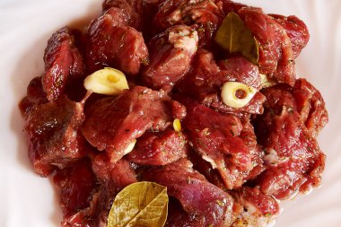 Baharatlı beyaz tabakta marine edilmiş sığır eti. Et arka planı. Et yakın çekim.