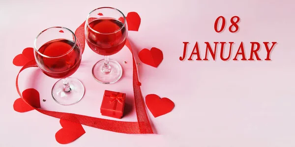 Fecha del calendario sobre fondo claro con dos copas de vino tinto, caja de regalo roja y corazones rojos con espacio para copiar. El 8 de enero es el octavo día del mes —  Fotos de Stock