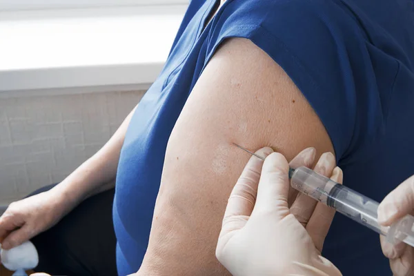 Arzt gibt Impfstoff für Patienten, Grippe-Impfung. Arzt macht Impfung in der Schulter des Patienten — Stockfoto