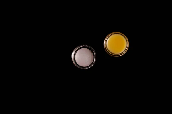Kosmetischer Gelbbalsam anderer Hersteller für die tägliche Hautpflege auf schwarzem Hintergrund. Konzept für Hautpflegeprodukte — Stockfoto
