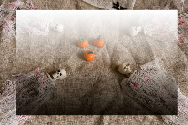 Concepto de Halloween con calabazas, esqueletos y juguetes de arañas sobre un fondo gris arrugado con espacio para copiar — Foto de Stock