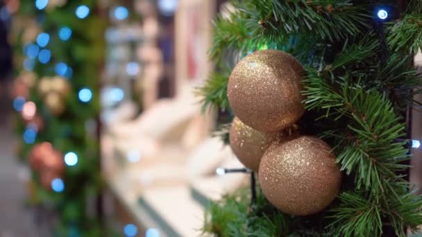 Kerstversiering op een etalage, dennenboom met gouden ballen, verlichting — Stockvideo