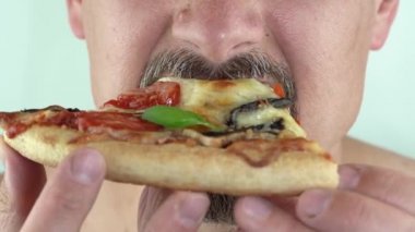 Yakın plan, sakallı ve bıyıklı bir adam pizza yiyor, 4K