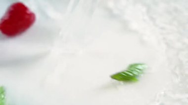 Ahududu, yaban mersini, nane ve suyla birlikte beyaz bir yüzeye dökülür.