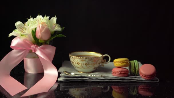 Composition of a cup of tea with macaroons and a bouquet of flowers, copy space — Stock Video