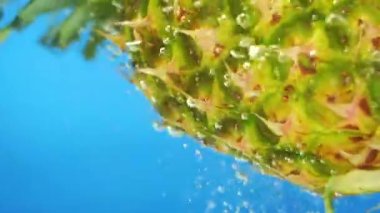 Mavi arkaplanda baloncukları olan ananas kopyalama alanı yavaş çekim düşen su
