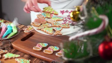 Noel zencefilli ekmek, renkli kremalı şeker, kadın elleri pasta topluyor.