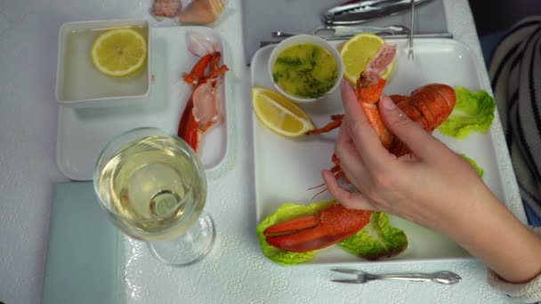 Female hands remove meat from the lobster claws with a fork, 4K top view — Wideo stockowe