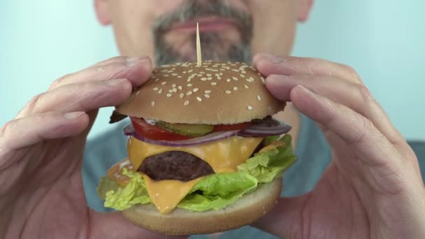 Hladový muž středního věku nenasytně jíst vegetariánské burgher, 4K close up copy space — Stock video
