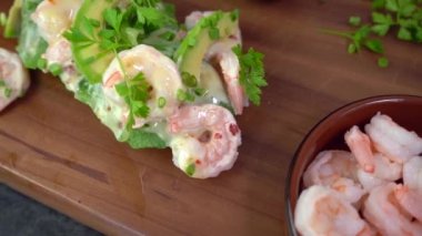 Piyon, avokado, salata, maydanoz ve peynir soslu baget sandviç.