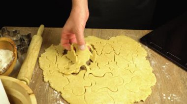 Erkek elleri hamurdan Noel kurabiyesi kesiyor, 4K yakın plan.