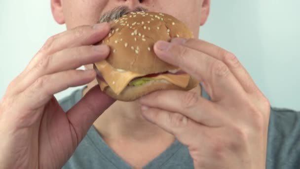 Hladový muž středního věku nenasytně jíst vegetariánské burgher, 4K close up copy space — Stock video