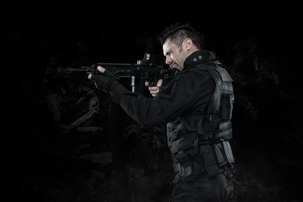 Spec ops police officer SWAT in black uniform studio — Stock Photo, Image