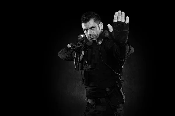 Spec ops police officer SWAT in black uniform studio — Stock Photo, Image