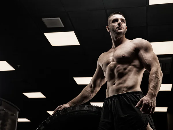 Όμορφος άντρας με μεγάλους μυς, ποζάρει στην κάμερα του γυμναστηρίου. — Φωτογραφία Αρχείου