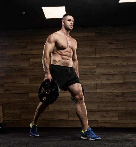 Stilig man med stora muskler, poserar vid kameran i gymmet — Stockfoto