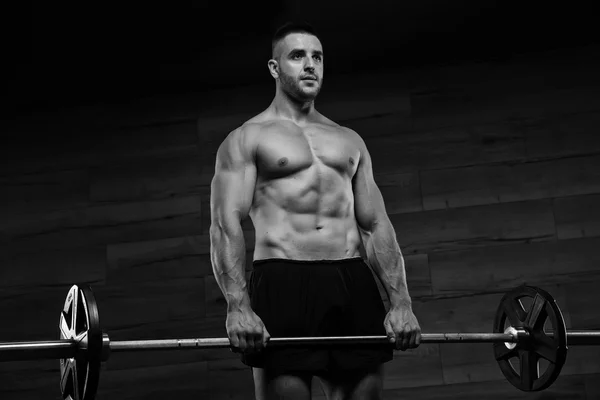 Stilig man med stora muskler, poserar vid kameran i gymmet — Stockfoto