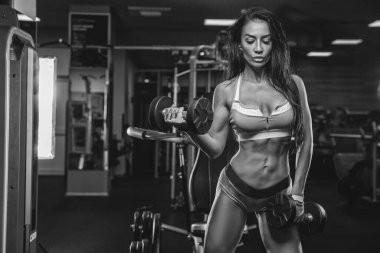 Genç bir atletik kız spor malzemelerini kullanarak egzersiz yapıyor..