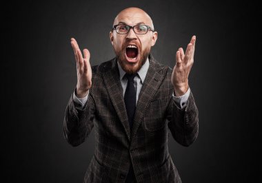 Gözlük, sakal, bağıran adam. Yaygın olarak ellerini koyar.