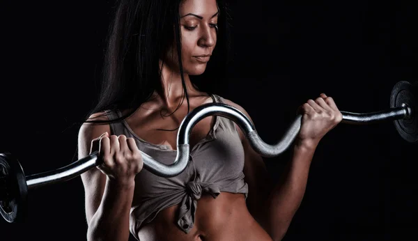 Жестокая атлетичная женщина накачивает мышцы гантелями — стоковое фото